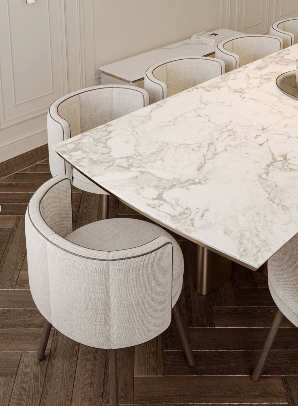 Detale aranżacji jadalni: marmurowy stół, tapicerowane krzesła z ciemną lamówką, drewniana podłoga w jodełkę, subtelne oświetlenie i minimalistyczny kredens.