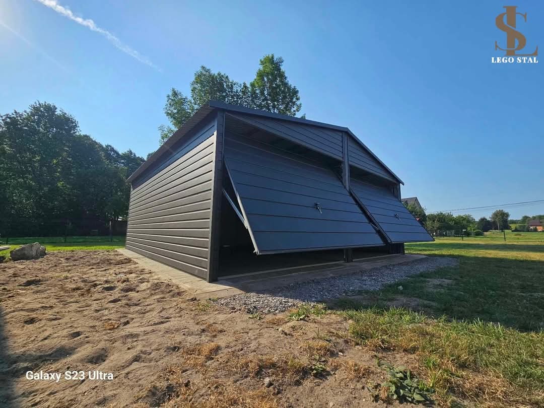 Ciemny garaż blaszany z dwoma uchylonymi bramami segmentowymi, widok z zewnątrz na trawnik i pole, logo firmy w prawym górnym rogu.