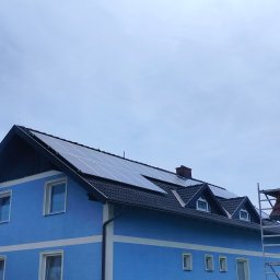 ETP Solution - Niebieski dom z panelami słonecznymi na dachu, widoczne rusztowanie z boku.