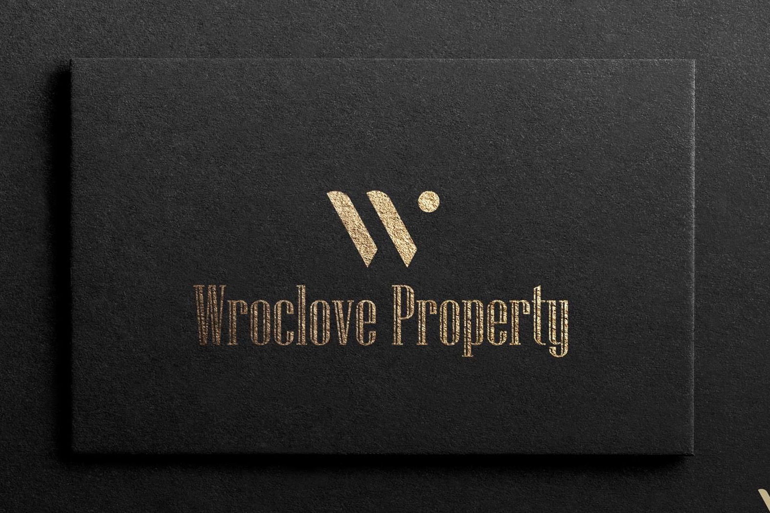 Czarna wizytówka z wytłoczonym złotym logo i napisem 'Wroclove Property' na teksturowanym tle.