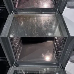 Zdjęcie przedstawia wnętrze piekarnika w dwóch ujęciach: górne ukazuje wnętrze silnie zabrudzone tłuszczem i resztkami jedzenia, dolne prezentuje wnętrze po czyszczeniu, z widoczną czystą...