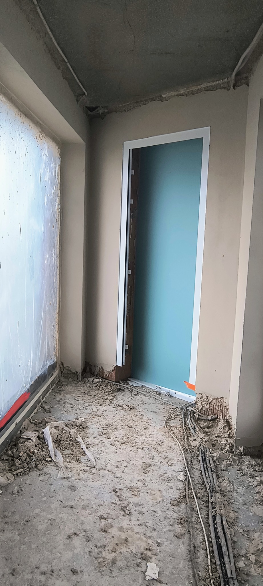 Stan surowy w Lublińcu: widok na wnętrze w trakcie remontu, z nowymi ościeżnicami drzwiowymi, nieotynkowanymi ścianami i instalacją elektryczną na podłodze.