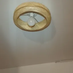 Zamontowana lampa sufitowa z abażurem z naturalnego rattanu, widoczna z dołu, pod spodem drabina.