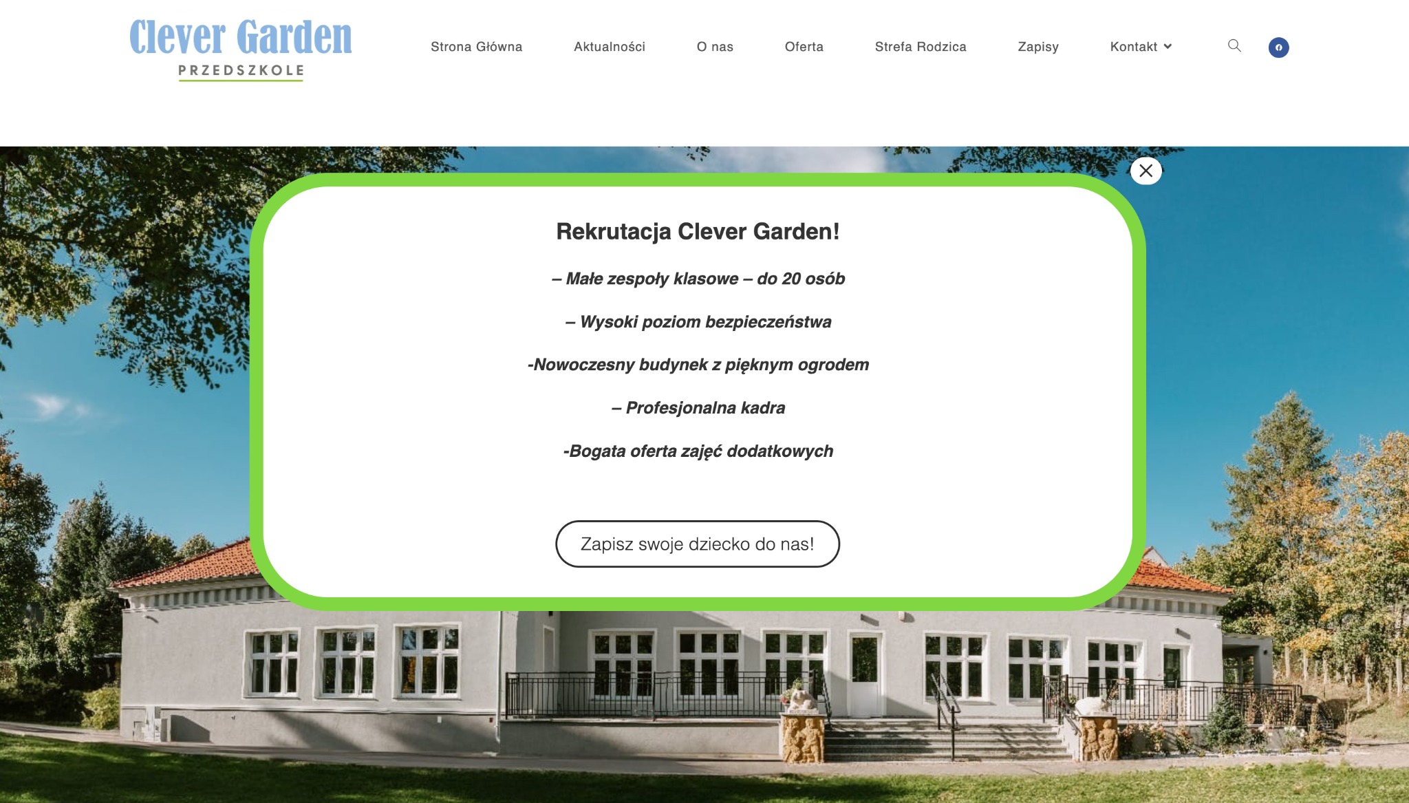 Strona internetowa przedszkola Clever Garden z wyskakującym okienkiem informującym o rekrutacji, widok na budynek przedszkola i część ogrodu.