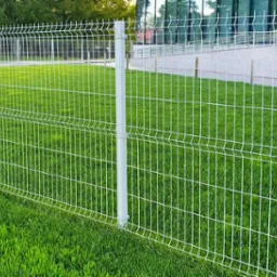 Nowoczesne, białe ogrodzenie panelowe z metalu, zamontowane na trawniku w Poznaniu, z budynkiem biurowym w tle.