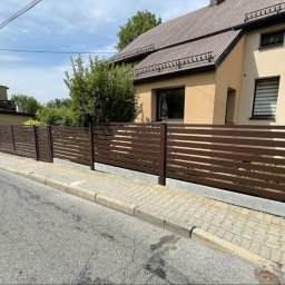 AMTRANS ANTONI OGIERMAN - Nowoczesne ogrodzenie posesji z poziomych, brązowych profili, widoczne z perspektywy ulicy, z domem w tle.