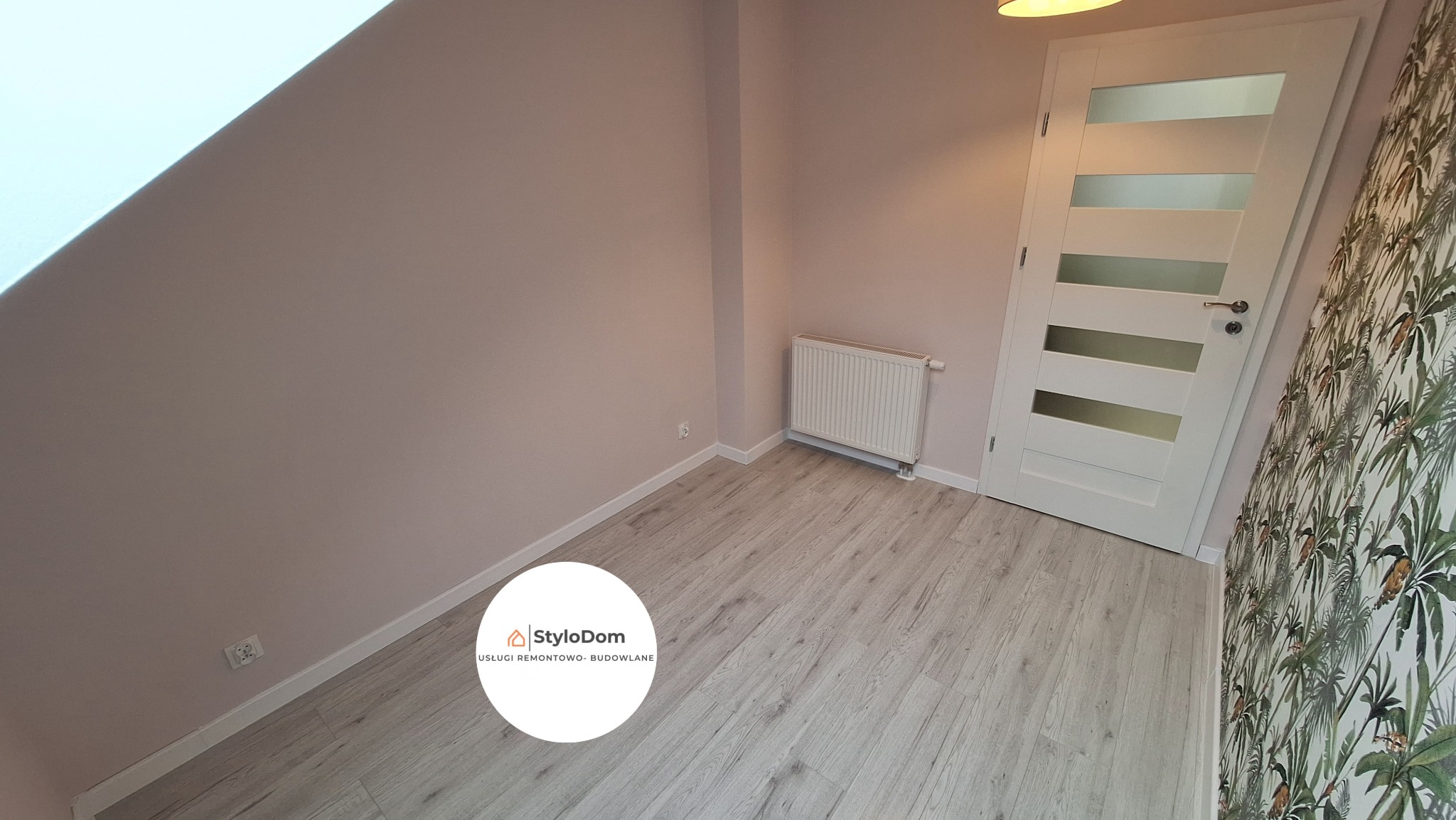 Pokój po remoncie: pastelowe ściany, jasne panele podłogowe, białe drzwi z przeszkleniami, grzejnik i fragment ściany z tapetą w tropikalne liście.