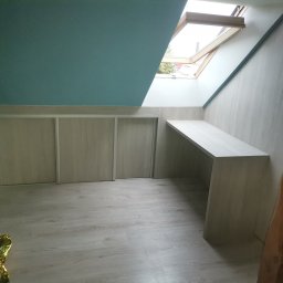 MARCIN KOŁODZIEJCZAK - Szafa wnękowa z przesuwnymi drzwiami i biurko zamontowane na poddaszu z oknem dachowym, szare panele na podłodze, niebieski sufit.