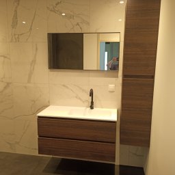 Mariusz Markowski - Nowoczesna łazienka z marmurowymi płytkami, szafką pod umywalką z ciemnego drewna i dużym lustrem z czarną ramą, minimalistyczna armatura.