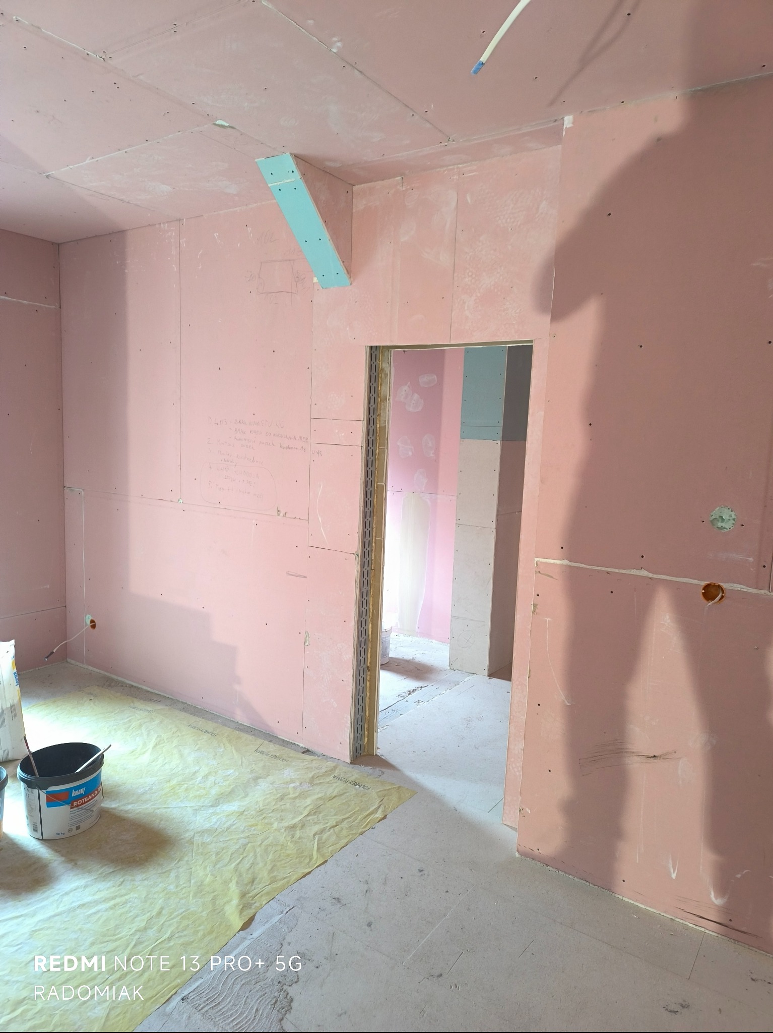 Montaż płyt karton-gips w Gorzowie Wielkopolskim. Widoczne ściany i sufit pokryte płytami, przygotowane do dalszych prac wykończeniowych. Na podłodze folia ochronna.