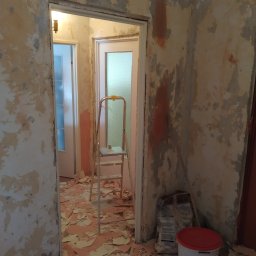 Piotr Malinowski - Pokój w trakcie usuwania starej tapety, z widoczną drabiną, workiem z klejem i wiadrem z napisem Betonkontakt.