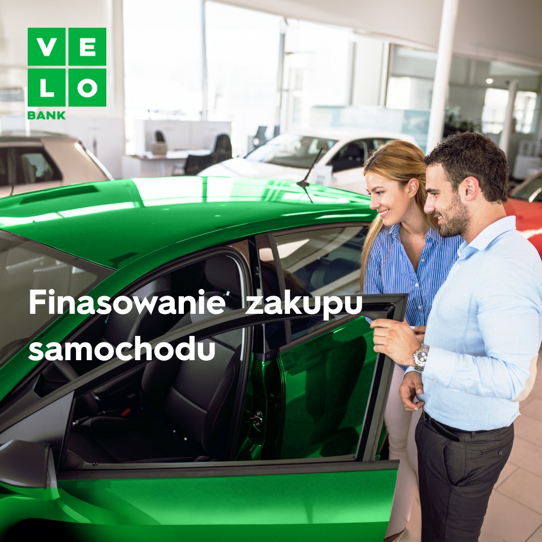 Para ogląda zielony samochód w salonie; widoczne logo banku Velo