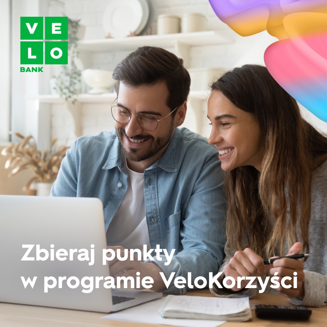 Para w Warszawie, uśmiechnięta, korzysta z laptopa i programu lojalnościowego banku. Na biurku notatnik i kalkulator.