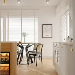 Jasna kuchnia w Szczecinie z drewnianą podłogą w jodełkę, okrągłym stołem i krzesłami z rattanu. Na ścianie mapa Madrytu w czarnej ramie.