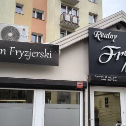 Klimak Wojciech Makowski - Dwa lokale fryzjerskie obok siebie z zamontowanymi roletami zewnętrznymi i klimatyzacją. Na fasadzie widoczne szyldy z nazwami salonów.