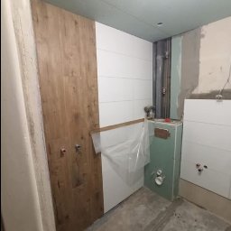 Mała łazienka w bloku. Miejsca niewiele ale weszło wszystko co trzeba. Połączenie bieli i ciepłej płytki drewnopodobnej to coś co szybko się nie znudzi i raczej z mody nie wyjdzie. 