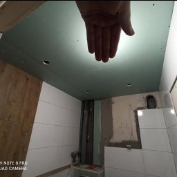 Mała łazienka w bloku. Miejsca niewiele ale weszło wszystko co trzeba. Połączenie bieli i ciepłej płytki drewnopodobnej to coś co szybko się nie znudzi i raczej z mody nie wyjdzie. 