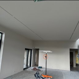 Łukasz Skawski - Wnętrze w trakcie prac wykończeniowych: ściany i sufit po szpachlowaniu, przygotowane do malowania, widoczny podnośnik do płyt oraz szlifierka do gipsu