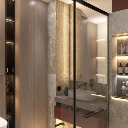 E.HOME Ewelina Szydełko - Nowoczesna łazienka z kabiną prysznicową typu walk-in, marmurowymi ścianami, podświetlanymi półkami w ścianie i umywalką nablatową na czerwonej szafce.