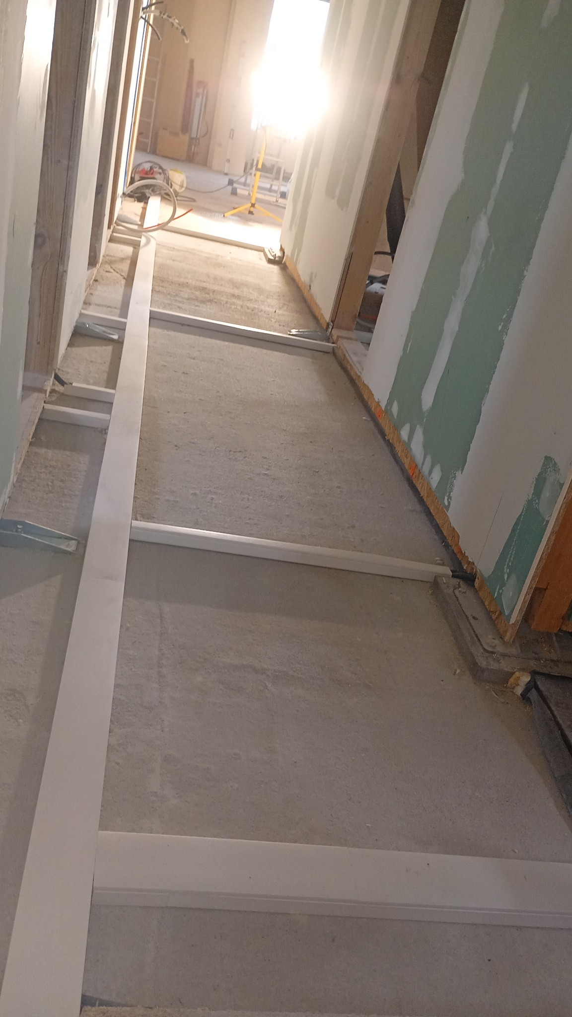 Montaż ścian działowych z płyt gipsowo-kartonowych na metalowym stelażu. Widoczne profile i płyty w trakcie instalacji, surowe wykończenie wnętrza.