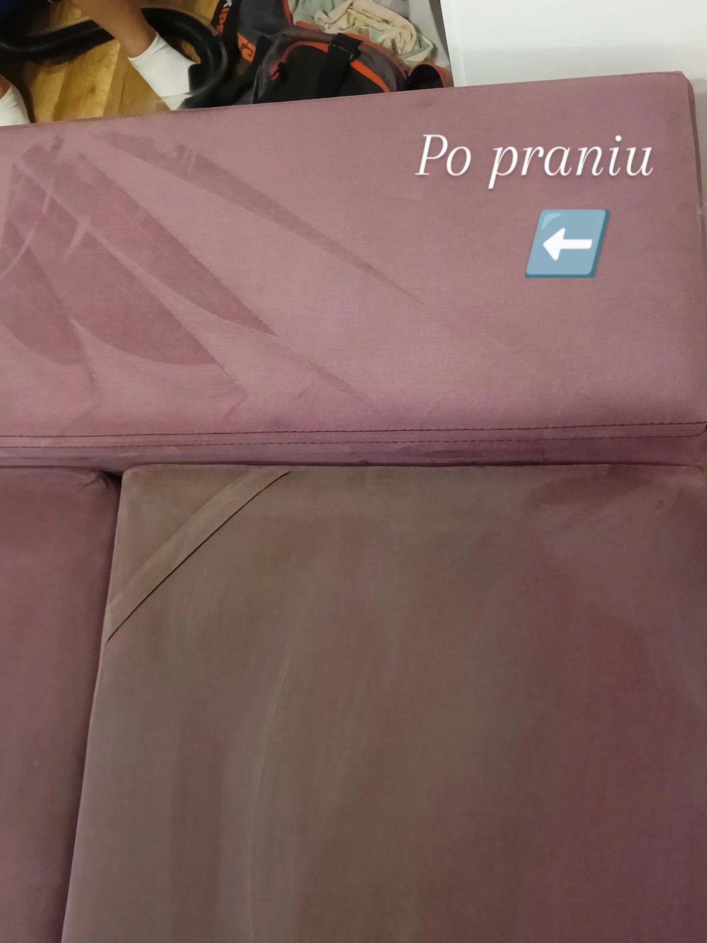 Różowa kanapa po praniu, widoczne ślady czyszczenia. Na górze napis 'Po praniu' ze strzałką. Część odkurzacza widoczna w rogu.