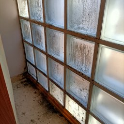 Martyna Kołucka Operacja Błysk - Zabrudzone luksfery z widocznymi zaciekami i osadami, osadzone w ramie, zanieczyszczona podłoga w tle.