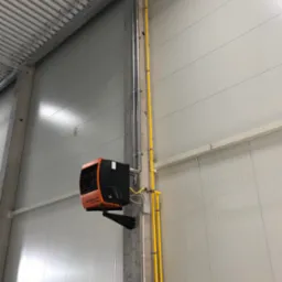 Zamontowany piec grzewczy Robur NEXT-R40 na betonowym słupie w hali, widoczne rury gazowe w kolorze żółtym i instalacja odprowadzająca spaliny, sufit z blachy trapezowej.