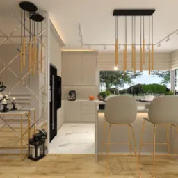 Nowoczesna kuchnia w jasnych odcieniach z wyspą, krzesłami barowymi na złotych nogach i dekoracyjnym lustrem na ścianie.