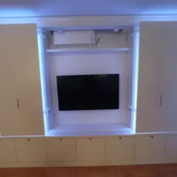 Biała szafa wnękowa z przesuwnymi drzwiami, podświetleniem LED i miejscem na telewizor, z widocznym klimatyzatorem w górnej części wnęki.