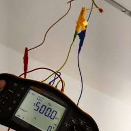 Automatyka Energetyka Zabezpieczenia - Miernik Fluke 1664 FC podczas pomiaru rezystancji izolacji instalacji elektrycznej. Widoczne przewody pomiarowe z krokodylkami podłączone do instalacji.