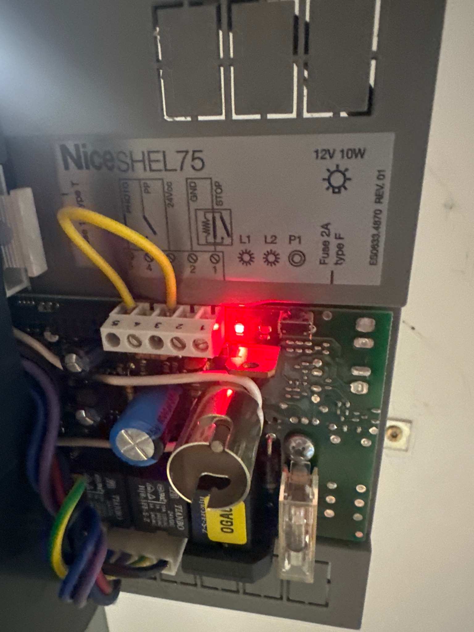 Działająca elektronika Nice SHEL75 z czerwoną diodą, widoczne kable i bezpieczniki, instalacja w Drezdenko. Praca elektryka.