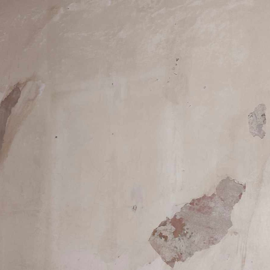 Niedokładnie położona gładź na ścianie z widocznymi ubytkami i nierównościami, przygotowana do dalszych prac wykończeniowych.