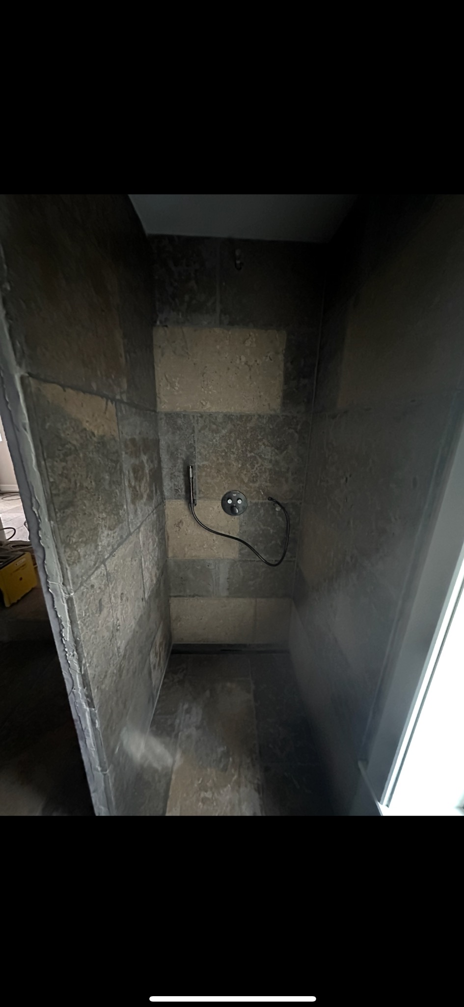 Wykończona kabina prysznicowa z szaro-beżowymi płytkami w Limanowej. Widoczna bateria i odpływ liniowy. Estetyczne i funkcjonalne rozwiązanie.