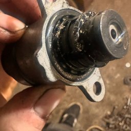 KK Performance JAKUB KOŹBIAŁ - Brudny, metalowy element samochodowy trzymany w dłoni, widoczne ślady zużycia i zanieczyszczenia.