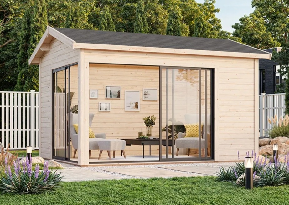 Nowoczesna, jasna altana ogrodowa z dużymi przesuwnymi drzwiami, umeblowana wewnątrz, otoczona zielenią i oświetlona lampami ogrodowymi.