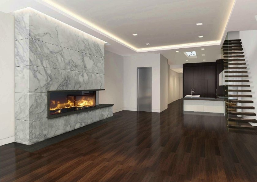Nowoczesny salon z marmurowym kominkiem, drewnianą podłogą i schodami z przezroczystą balustradą, widok na kuchnię z ciemnymi szafkami.