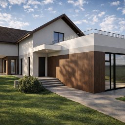 Biuro Projektowe Julia Szatko - Nowoczesny dom z płaskim dachem i drewnianą elewacją, otoczony zielonym trawnikiem i ścieżką. Minimalistyczny design, duże okna, błękitne niebo w tle.