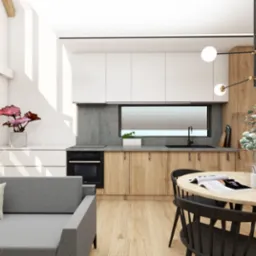 Nowoczesne wnętrze z szarą sofą, drewnianą podłogą i kuchnią w tle, oświetlone wiszącą lampą z kulistymi kloszami.