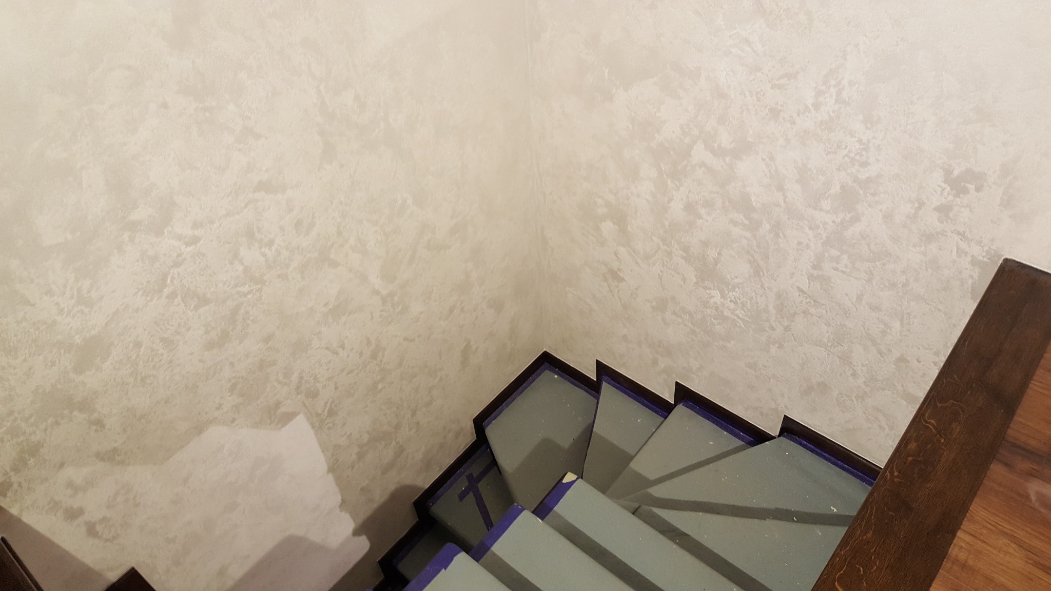 Ściana z dekoracyjną strukturą typu Sahara w odcieniach piaskowych, widoczna z góry przy schodach. Efektowna faktura, nowoczesne wykończenie wnętrza.