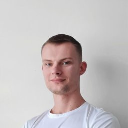 Pracownia Clinic & Formy Warszawa - fizjoterapia - dietetyka - trening medyczny - Portret młodego mężczyzny w białej koszulce, z lekkim uśmiechem i małym zadrapaniem na nosie, na jasnym, neutralnym tle.