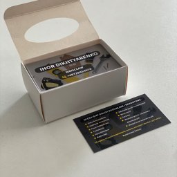 Magnetic design - Pudełko wizytówek z danymi kontaktowymi firmy remontowo-budowlanej IHOR DIKHTYARENKO, wraz z dodatkową wizytówką z ofertą usług, na jasnym tle.