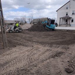 HYDRATOM TOMASZ ŻYHALUK - Przygotowanie terenu pod budowę przydomowej oczyszczalni ścieków: miniładowarka i minikoparka na placu budowy, widoczne ślady opon na ziemi i pryzma ziemi, w tle budynek mieszkalny.
