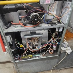 ZUH Broser - Otwarty piec gazowy z widocznymi elementami wewnętrznymi, w tym wentylatorem, przewodami i płytą sterującą. Widoczne ślady użytkowania i potencjalne zabrudzenia.