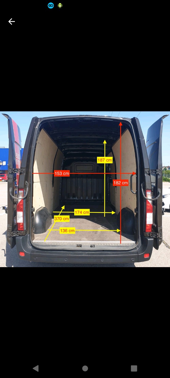 Wnętrze pustego, czarnego busa z otwartymi drzwiami, wymiary wnętrza zaznaczone żółtymi liniami i wartościami w centymetrach.
