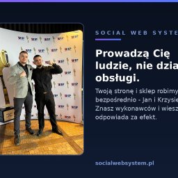Social Web System - Tworzenie stron internetowych - Dwóch uśmiechniętych mężczyzn pozuje z uniesionymi pięściami obok dużej, złotej statuetki widelca 'Polska od Kuchni' na tle ścianki z logo WIP.