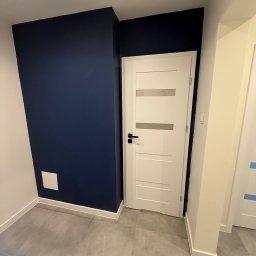 SERHII HULIAVSKYI sh.remontpro - Nowoczesne wnętrze: granatowa ściana, białe drzwi z przeszkleniami i szara podłoga z płytek. Minimalistyczny design, świeżo po remoncie.