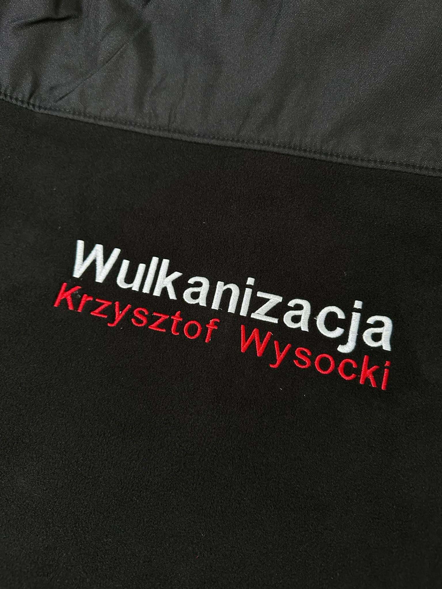 Czarne ubranie robocze z wyhaftowanym białym napisem 'Wulkanizacja' i czerwonym napisem 'Krzysztof Wysocki'.