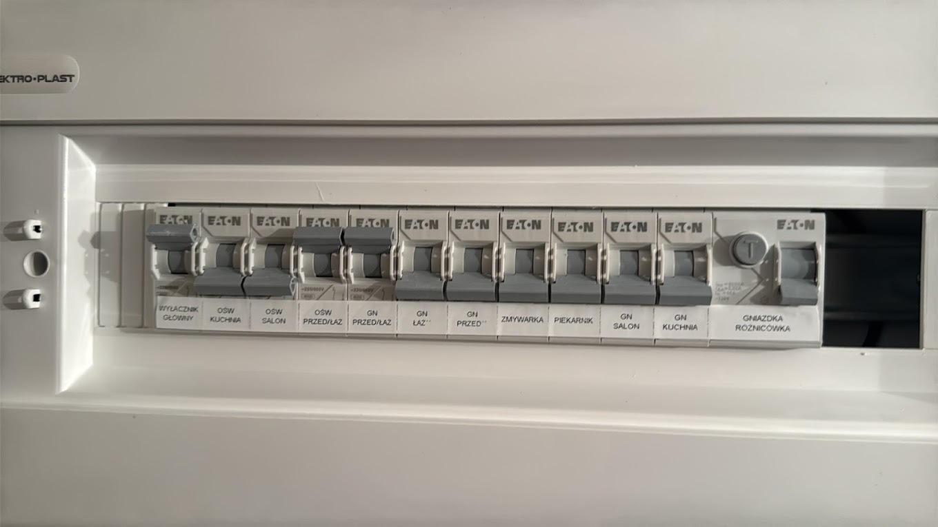 Szczegółowe ujęcie tablicy rozdzielczej z wyłącznikami Eaton w Tarnowskich Górach, opisane poszczególne obwody: oświetlenie, gniazda w kuchni, salonie, łazience, zmywarka, piekarnik. Jeden...