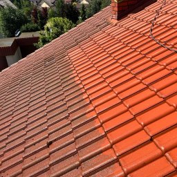 Firma Ogólnobudowlana Wiktor Marczak - Czerwona dachówka przed i po myciu ciśnieniowym. Widoczna wyraźna różnica w czystości połaci dachu. Część dachu umyta, część jeszcze zabrudzona.