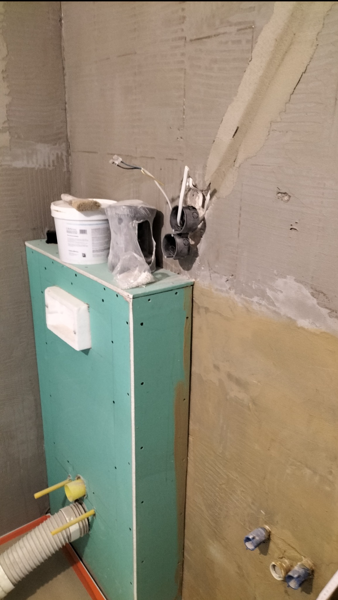 Prace instalacyjne w łazience w Masłowie: zabudowa stelaża WC z płyty GK, widoczne przyłącza wodne i kanalizacyjne, przygotowanie do dalszych prac wykończeniowych.